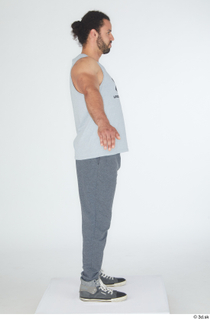 Simeon A poses dressed grey joggers grey sneakers grey tank…